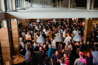 Crowded food industry networking event inside a pub, with attendees socialising and holding drinks.