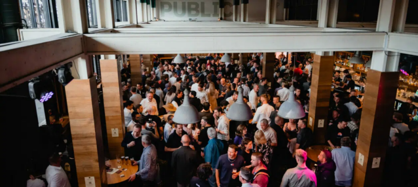Crowded food industry networking event inside a pub, with attendees socialising and holding drinks.