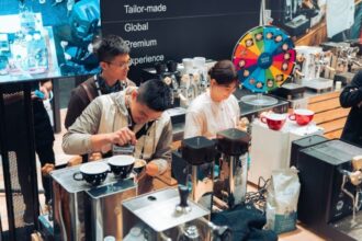 Baristas preparing coffee at espresso machines during a live demonstration at the Melbourne International Coffee Expo.