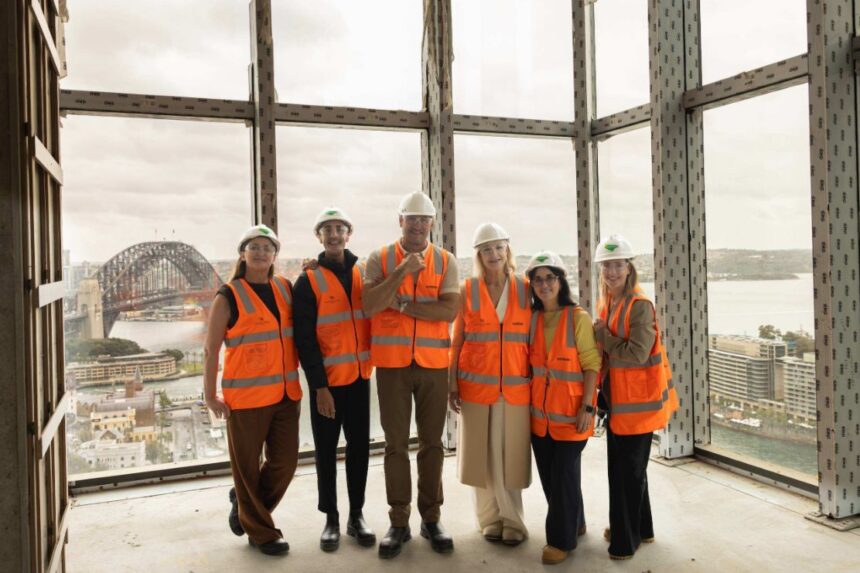 Curtis Stone and the Waldorf Astoria Sydney project team wearing high-visibility vests and hard hats at the hotel’s construction site overlooking Sydney Harbour.