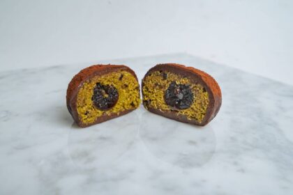 Dubai chocolate cookie cut in half to reveal pistachio kataifi filling and a molten chocolate centre.
