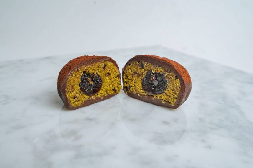 Dubai chocolate cookie cut in half to reveal pistachio kataifi filling and a molten chocolate centre.