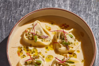 Forest mushroom tortellini served in a creamy sauce with herb oil, diced garnish and microgreens.