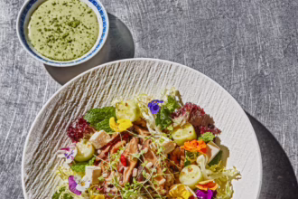 Barley and greens bowl with tofu, mushrooms, cucumber, edible flowers and matcha yuzu sauce.