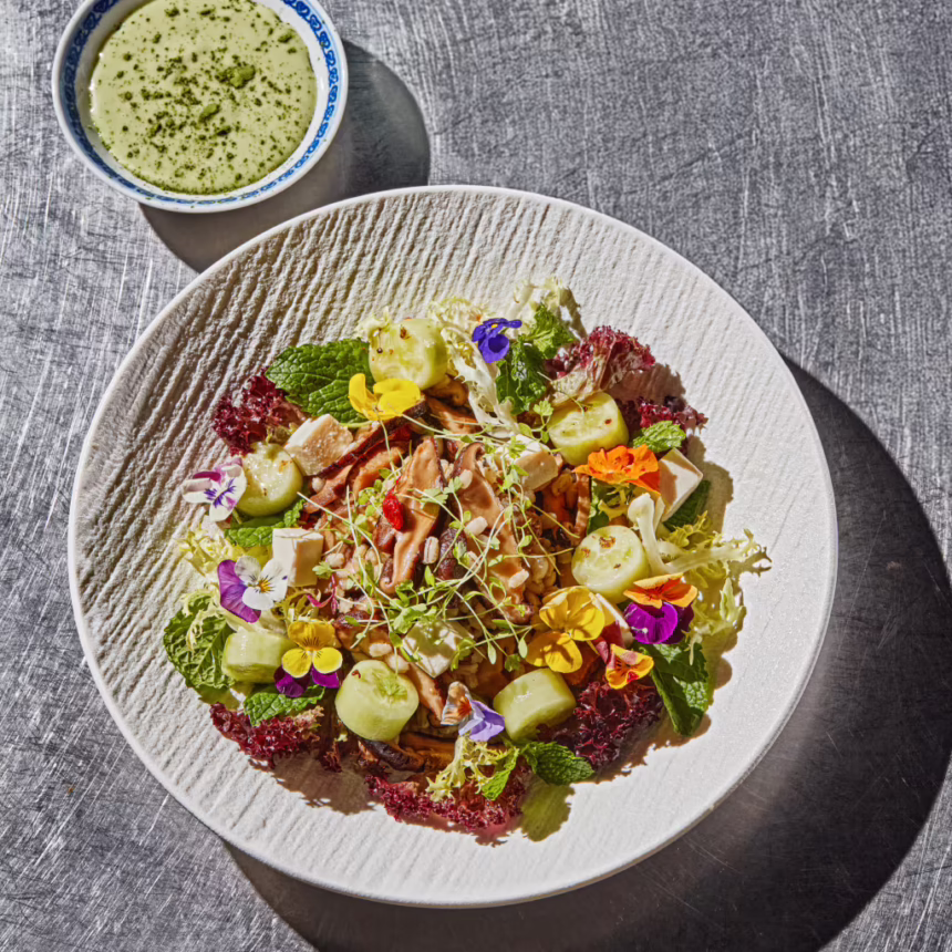 Barley and greens bowl with tofu, mushrooms, cucumber, edible flowers and matcha yuzu sauce.