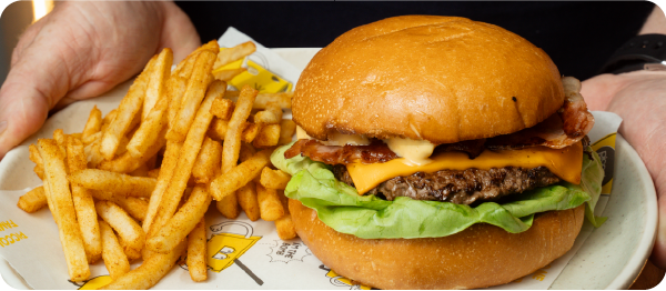 Piccolo Me beef burger with cheese, bacon, lettuce and sauce, served with seasoned fries.