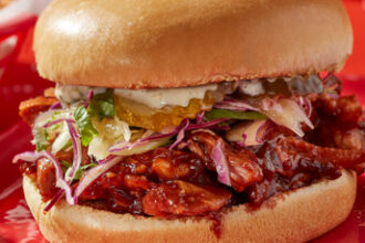 Pulled pork brioche burger topped with grilled pineapple, pickles and fresh slaw.