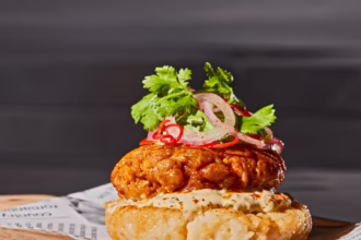 Open rice burger topped with Sai Oua sausage, creamy sauce, pickled onion, chilli and coriander.