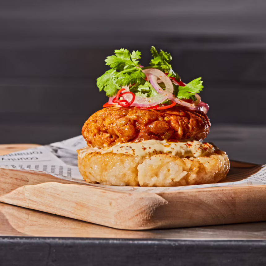 Open rice burger topped with Sai Oua sausage, creamy sauce, pickled onion, chilli and coriander.