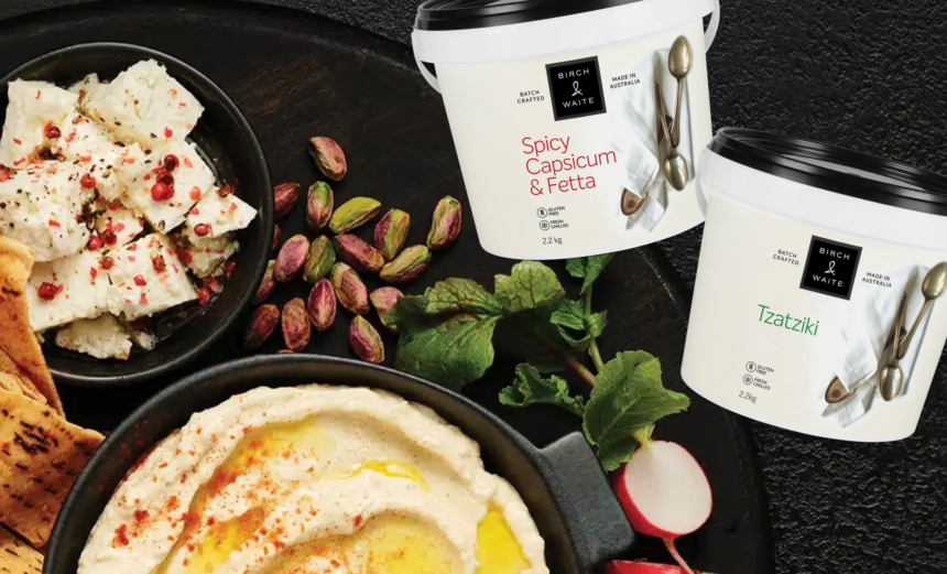 Birch & Waite 2.2kg tubs of Spicy Capsicum & Fetta and Tzatziki dips surrounded by flatbread, feta, pistachios and herbs.