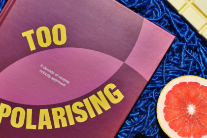 Brodie Nalywajko’s Too Polarising cookbook styled with vivid blue background, white chocolate and a halved grapefruit.