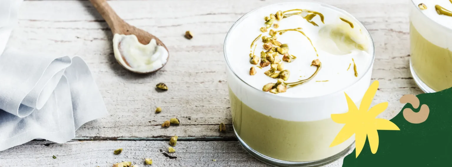Plant-based pistachio pudding topped with a creamy layer and chopped pistachios.