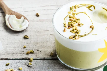 Plant-based pistachio pudding topped with a creamy layer and chopped pistachios.