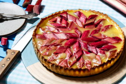 Roasted rhubarb and blood orange frangipane tart topped with pieces of pink rhubarb.