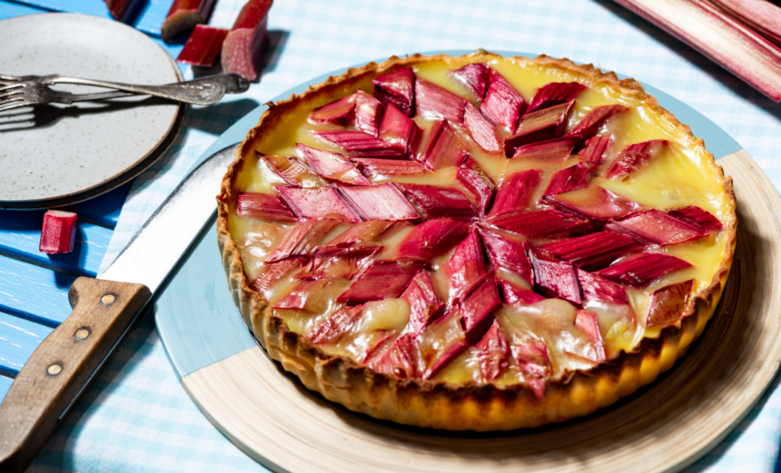 Roasted rhubarb and blood orange frangipane tart topped with pieces of pink rhubarb.